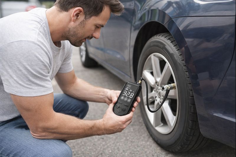 a man inflating his car tyre using a tyre inflator