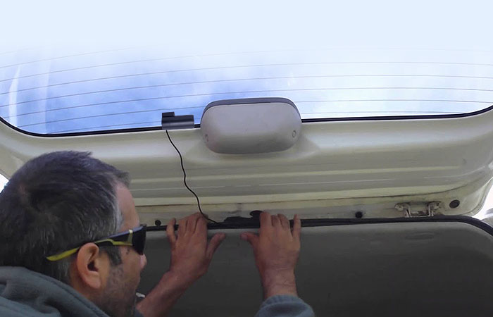 man installing rear view camera