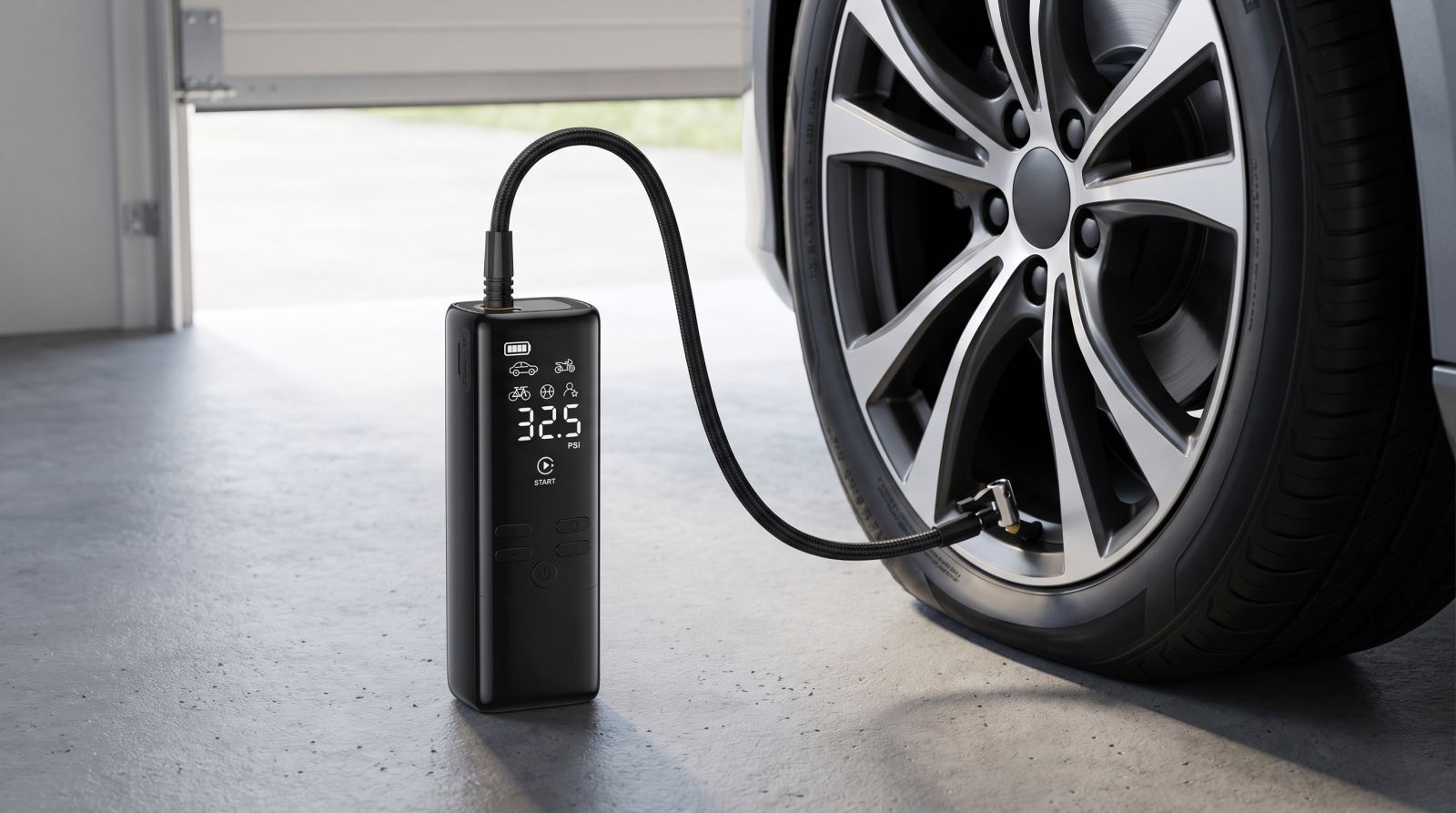 Portable digital tyre inflator connected to a car tyre in a garage while displaying the tyre pressure reading.