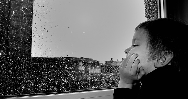 kid bored in car while raining