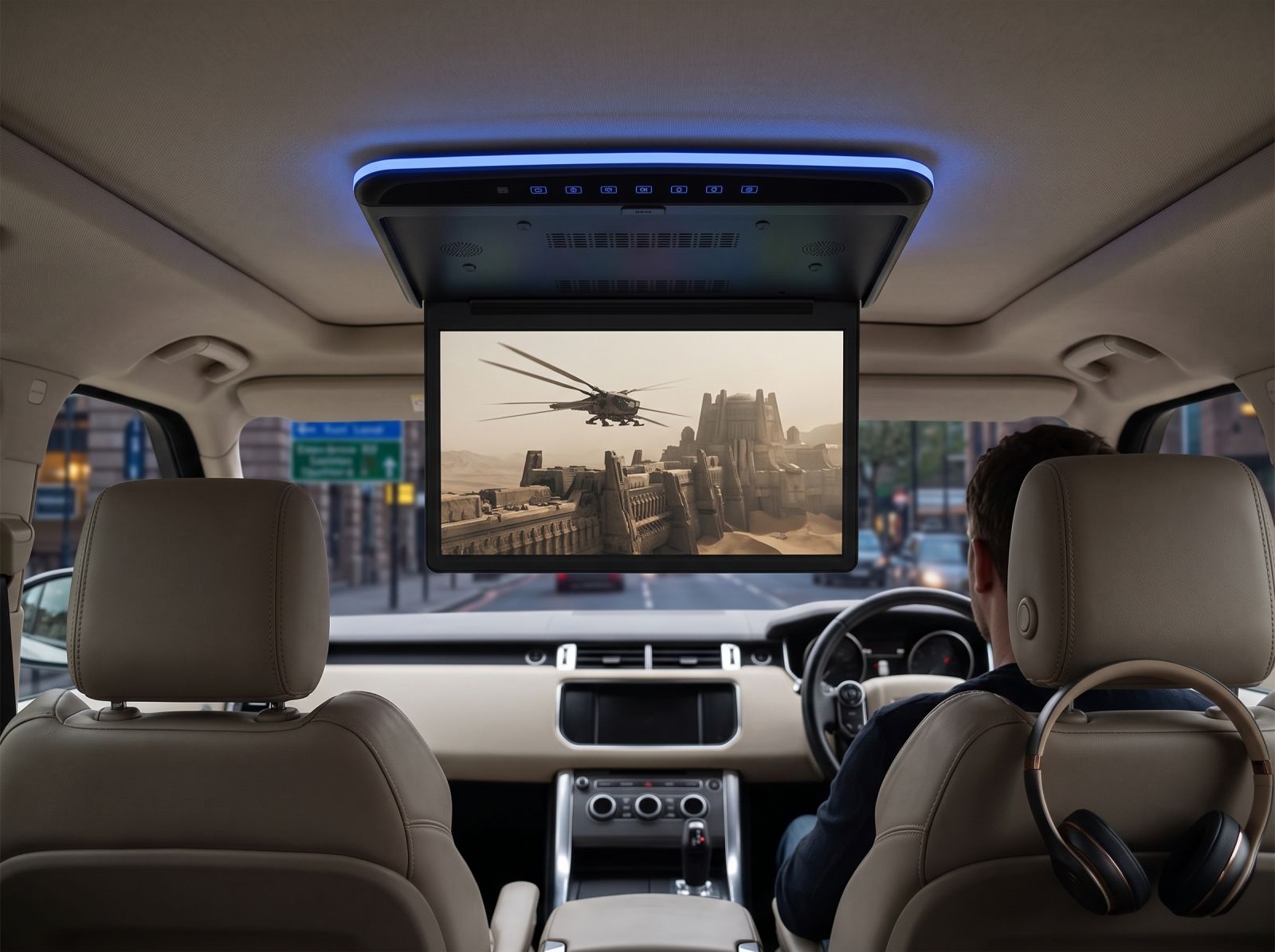 Roof-mounted flip-down car DVD player with overhead monitor playing a movie inside a modern SUV for rear passenger entertainment.